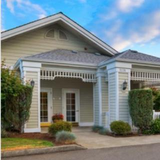 A charming residential house with a landscaped front yard and inviting porch.