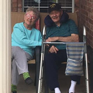 A cheerful elderly couple enjoying each other's company on their porch.