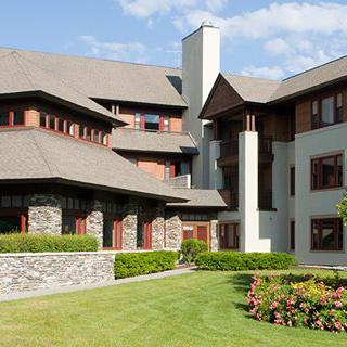 A modern residential building with a well-maintained lawn and garden.