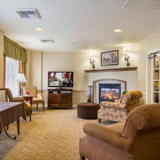 A cozy living room featuring a fireplace, comfortable seating, and warm decor.