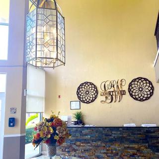 A welcoming lobby area featuring a reception desk, decorative wall art, and a hanging chandelier.