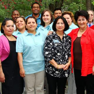 A group of people posing together outdoors, showcasing diversity and teamwork.