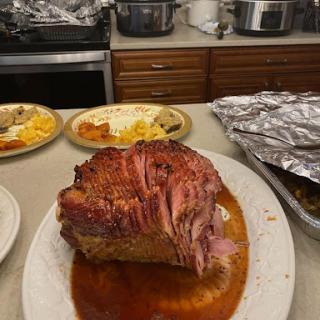 A beautifully glazed ham served on a platter, surrounded by side dishes.