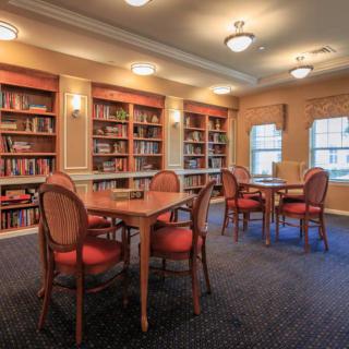 A quiet reading room with bookshelves, tables, and chairs.