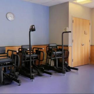 A room with exercise equipment designed for rehabilitation and healthcare purposes.