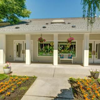 A charming house with a well-maintained front yard featuring vibrant flowers and hanging plants.
