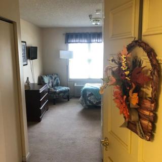 A cozy bedroom view from the door with autumn-themed decor.
