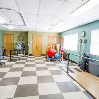 A physical therapy room equipped with parallel bars and exercise equipment.