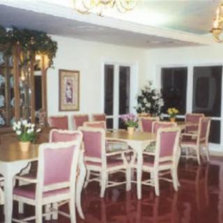 A stylish dining room with elegant tables and chairs, decorated with plants.