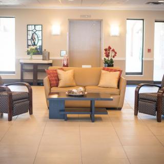 A modern lobby with a comfortable seating arrangement, including a sofa and armchairs around a coffee table.