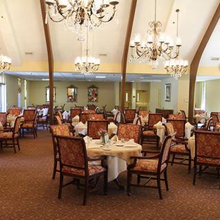 An elegant dining room with arranged tables and chandeliers.