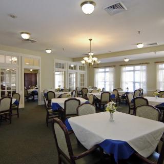 A spacious dining room with neatly arranged tables and chairs, featuring elegant decor and ample lighting.