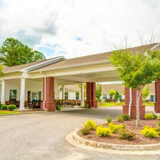 A welcoming building entrance with a covered driveway and manicured landscaping.