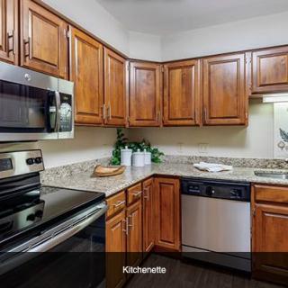 A modern kitchen with wood cabinets and stainless steel appliances.