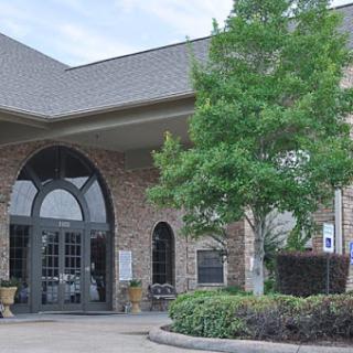 A beautifully designed building with an inviting entrance surrounded by greenery.