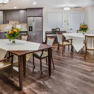 A modern kitchen and dining area with elegant furnishings and floral decorations.