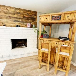 Cozy living room with a rustic wooden bar and fireplace.