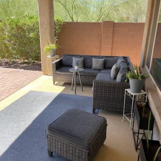 A cozy outdoor patio setup featuring modern furniture and potted plants.