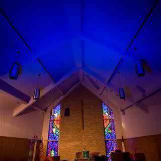 A church interior with colorful stained glass and ambient lighting.