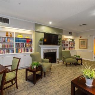 A cozy living room with bookshelves, a fireplace, and comfortable seating.