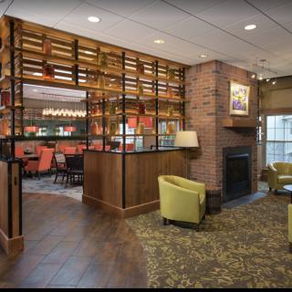 A cozy lounge area with modern design elements, featuring a fireplace and bar seating.