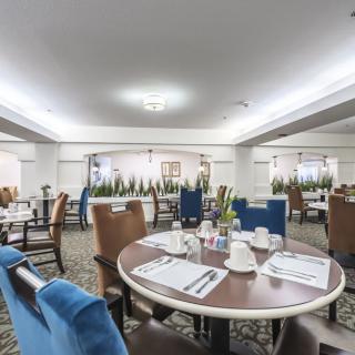 A spacious dining area with neatly arranged tables and chairs, set for a meal.