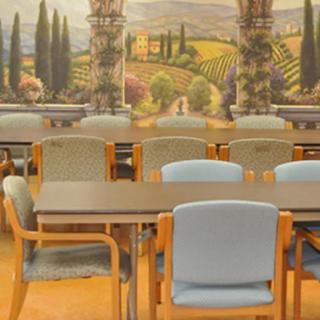 An empty conference room with chairs and tables in front of a scenic wall mural.
