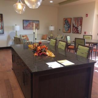 A modern dining room with a large table, surrounded by chairs and decorated with autumn-themed centerpieces.