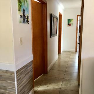 A well-lit hallway showcasing wooden doors and decorative artwork.