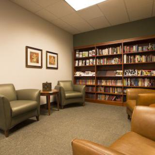 A cozy reading room with comfortable chairs and bookshelves filled with books.