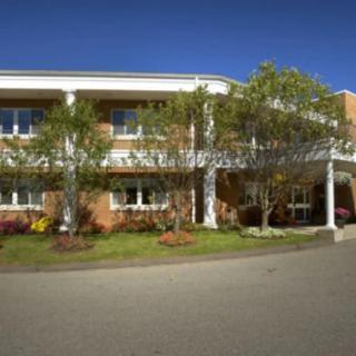 A two-story building with a landscaped entrance and driveway.