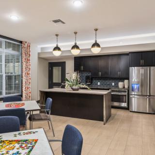 A modern kitchen with a dining area, featuring sleek appliances and stylish lighting.