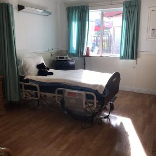 A hospital room with a bed near the window, sunlight streaming in.