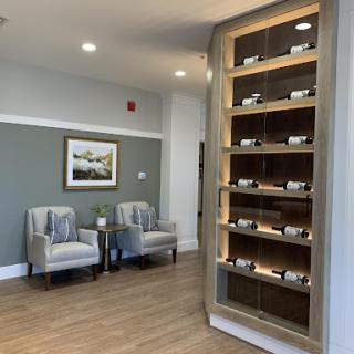 A modern waiting area featuring comfortable seating and a decorative display shelf.
