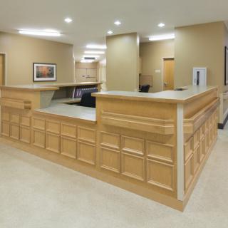 A modern office reception area with wood paneling and bright lighting.