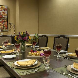 A beautifully set dining table with elegant decor and a centerpiece of flowers.