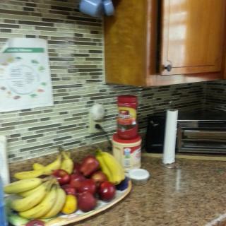 A kitchen countertop with a fruit bowl, canisters, and a toaster oven.