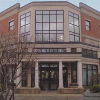 A modern commercial building featuring large windows and a classic brick facade.