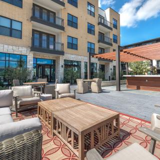 A modern apartment complex with stylish outdoor seating and patio furniture.