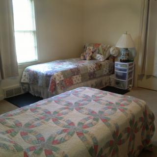 A cozy bedroom with two twin beds adorned with patchwork quilts.