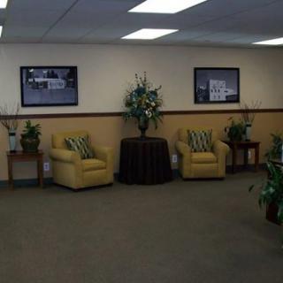A cozy waiting room with chairs and decorative plants.