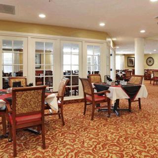 A cozy restaurant dining area with elegantly set tables and patterned carpet.