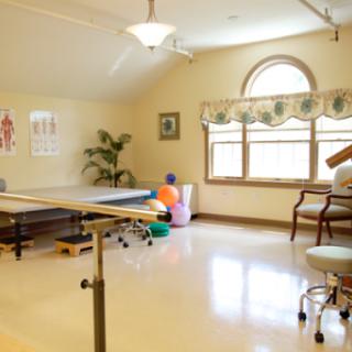 A spacious and well-lit therapy room equipped for rehabilitation exercises.