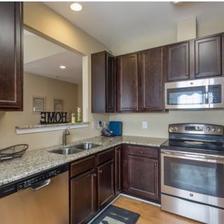 A modern kitchen with stainless steel appliances and granite countertops.