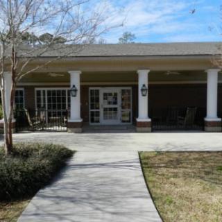 Front view of a building with a porch and columns leading to the entrance.