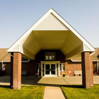 A covered entrance to a brick building with large pillars.