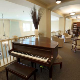 A cozy interior with a grand piano and comfortable seating area.