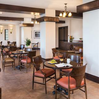 A cozy restaurant dining area with neatly arranged tables and chairs, featuring elegant lighting and inviting decor.