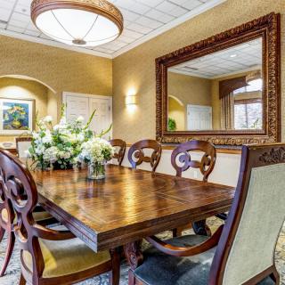 Elegant dining room with a wooden table, ornate chairs, and a decorative mirror.