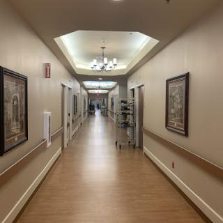 A well-lit interior hallway featuring decorative frames on the walls.
